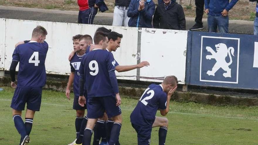 Míkel, arrodillado, celebra el gol del Marino con sus compañeros detrás.