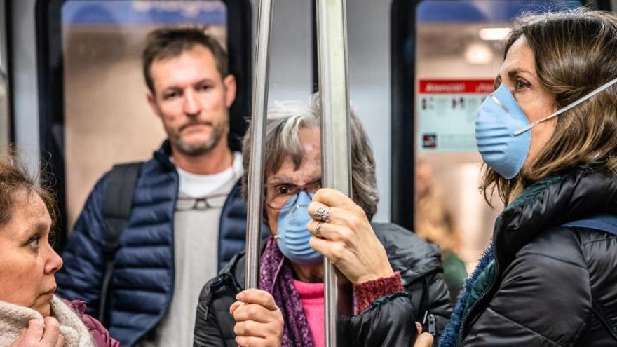 Personas con mascarillas en el meto de Barcelona.