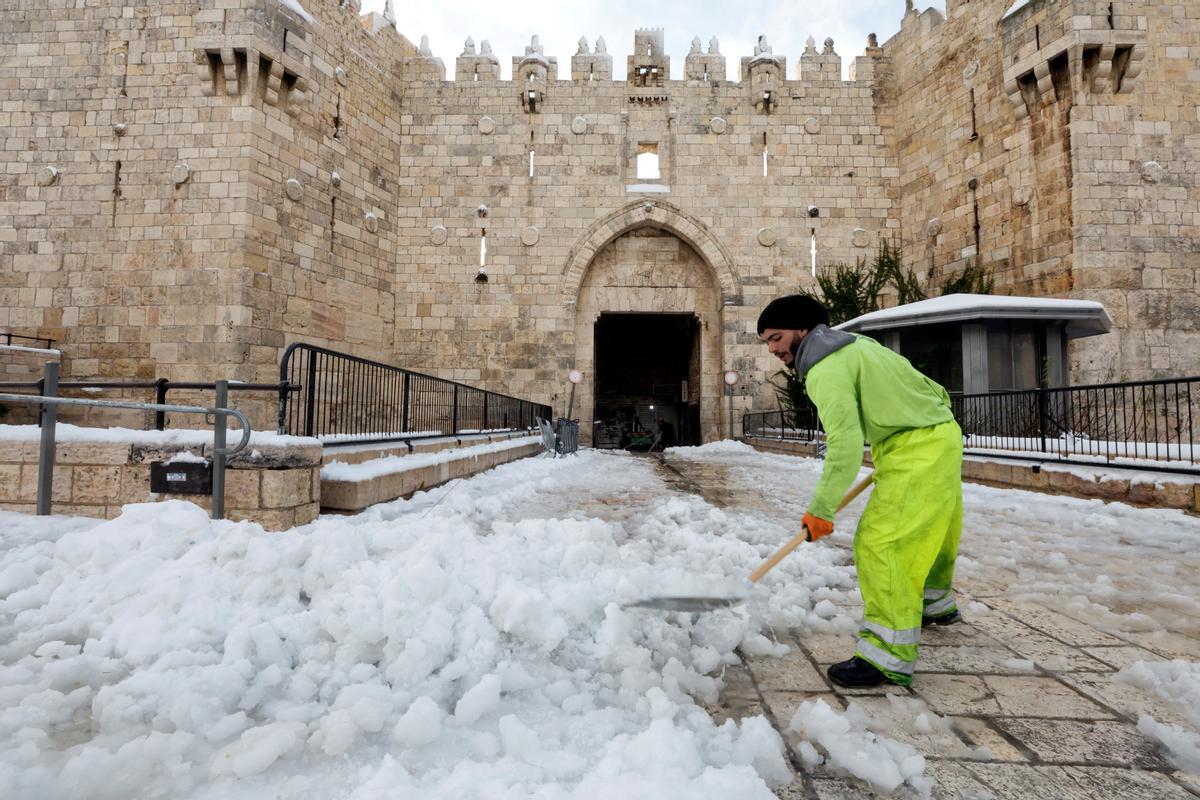 Trabajos de retirada de la nieve frente a la puerta de Damasco, en la ciudad vieja de Jerusalén.