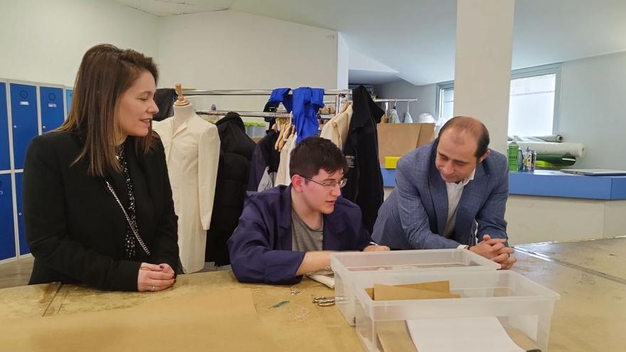 El edil Empleo, Marcos Óscar Martínez, con la técnica municipal Mónica Iglesias, con uno de los alumnos, durante la visita al taller que se imparte en el centro social de Soto de Llanera.