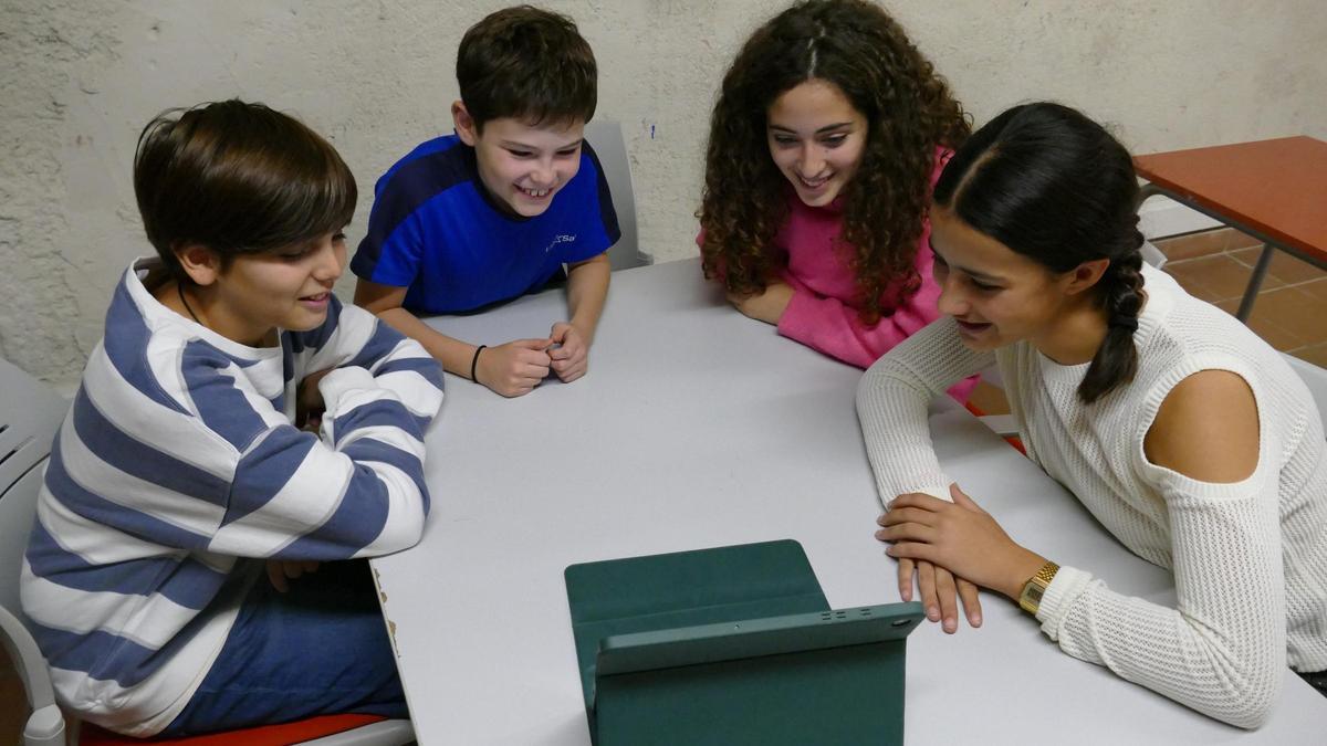 La Bruna, en Teo, la Marta i en Lluc veient, per primera vegada, el resultat final del conte (en format digital).