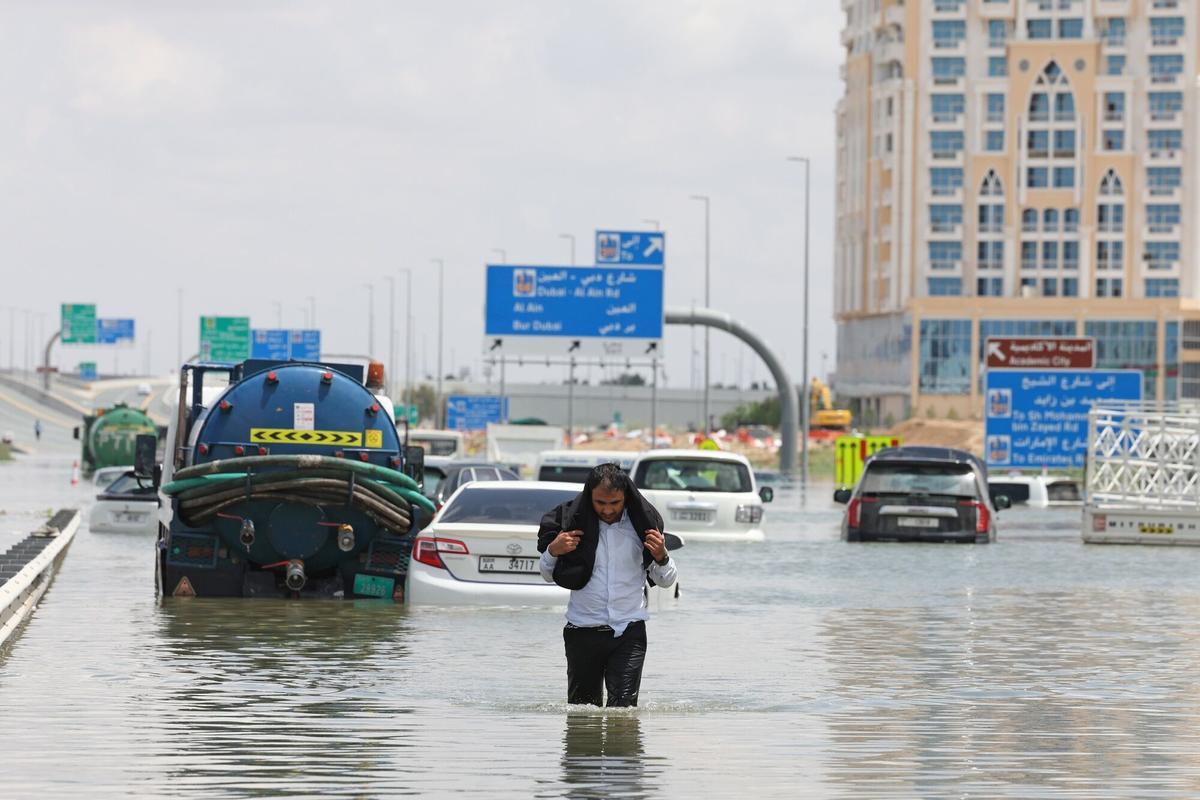 Un hombre camina, el miércoles, por una carretera inundada de Dubái tras las lluvias