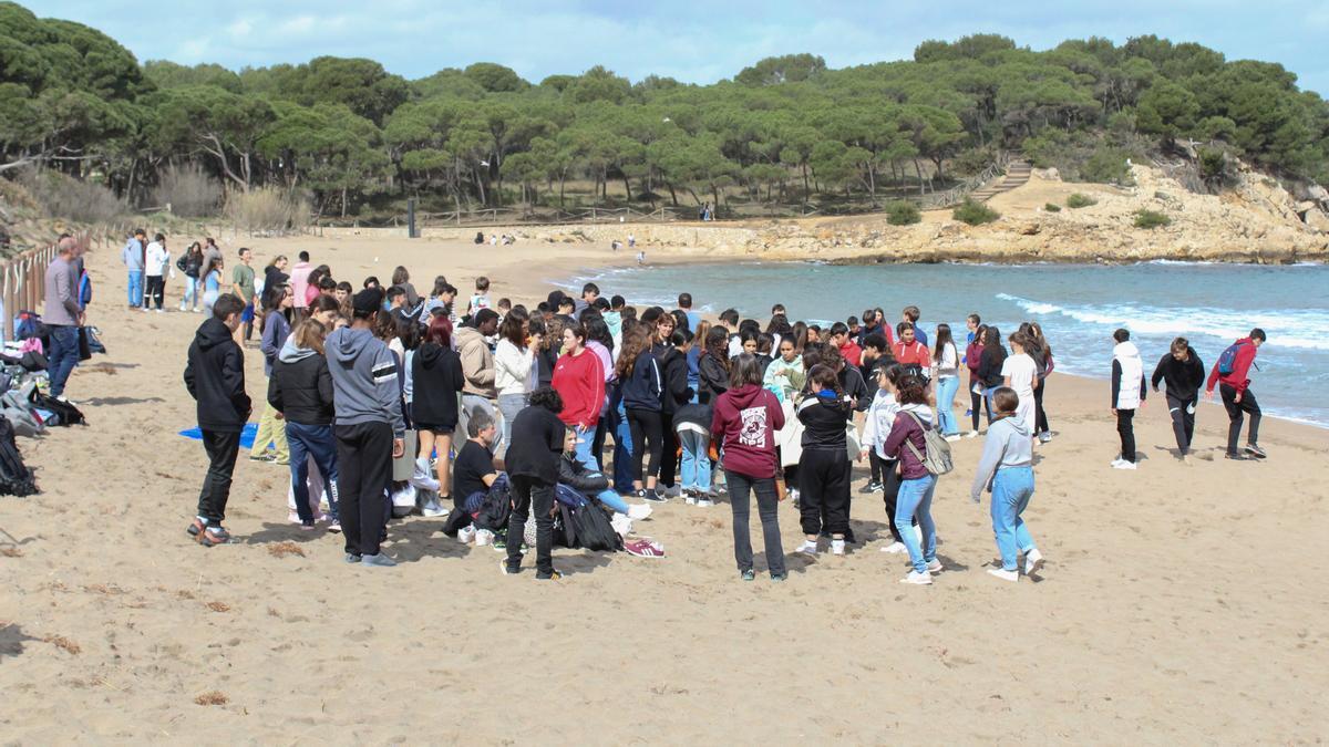 Diversos alumnes de secundària de l'Escala recullen escombraries a la platja de Sant Martí d'Empúries