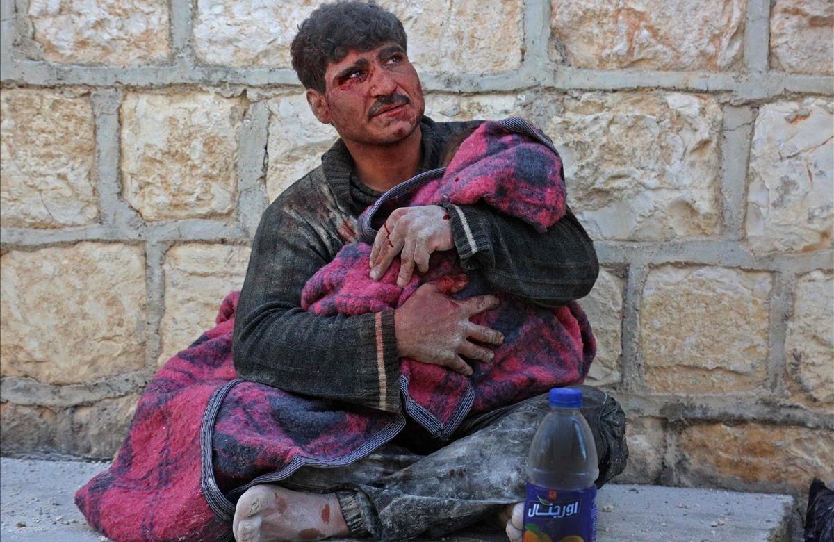 Un hombre sirio llora mientras acuna el cuerpo de su hija que murió después de los bombardeos en la ciudad de Khan Sheikhun, en el campo sur de la provincia de Idlib, controlada por los rebeldes.