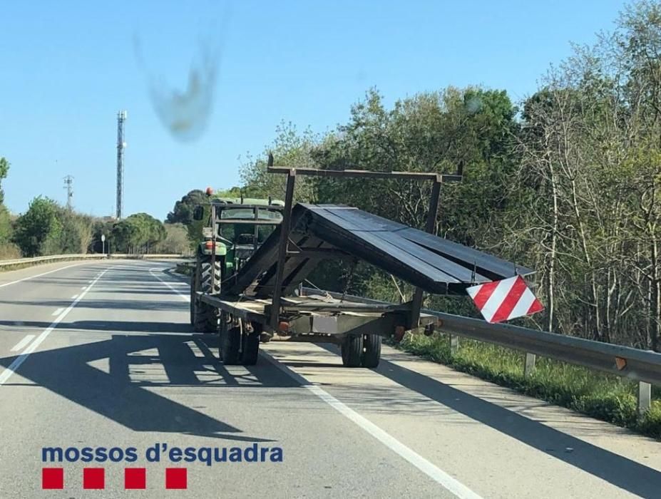 Les bigues de ferro sobresortien el remolc del tractor