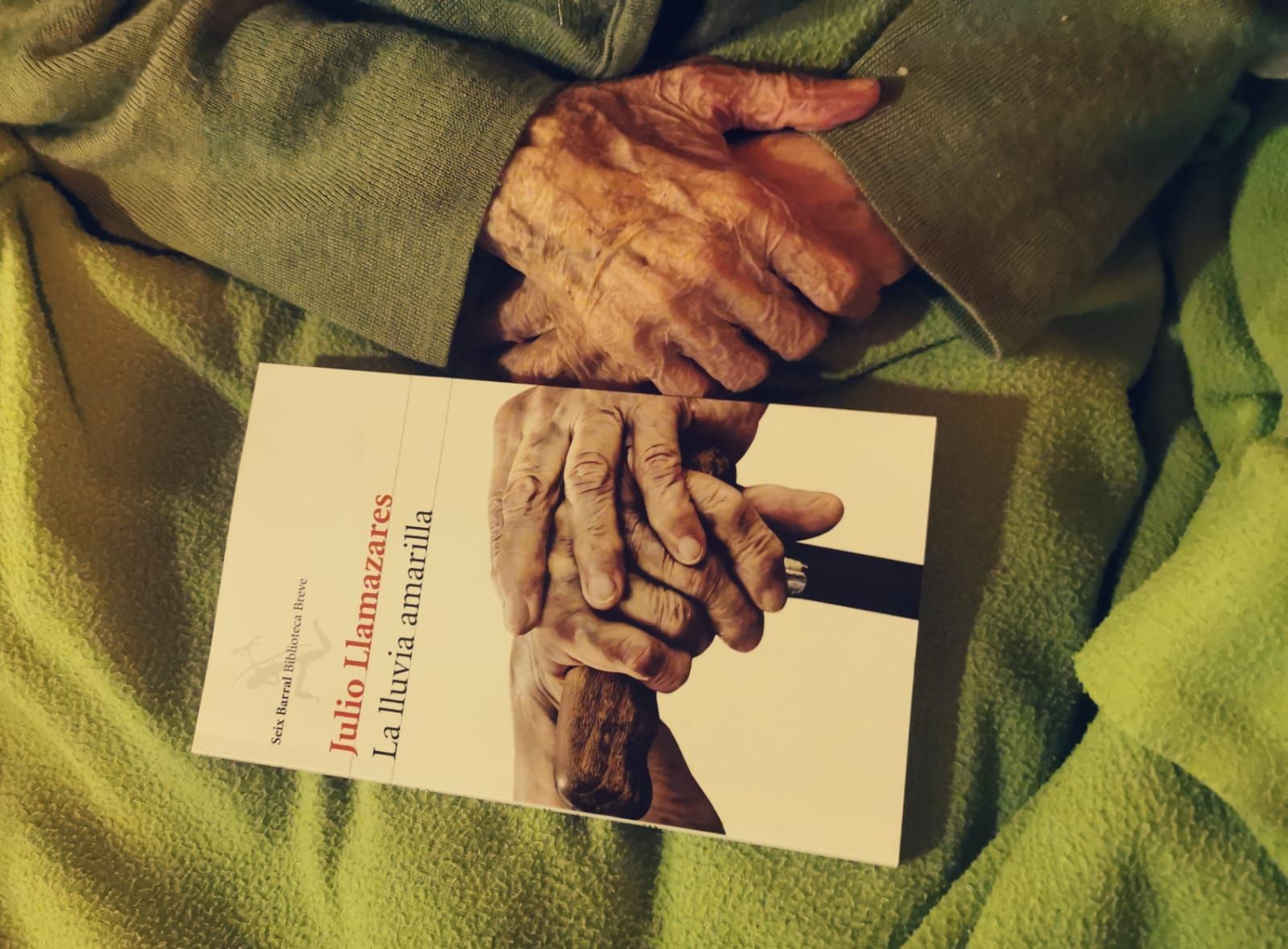 Las manos de María de Ruidelamas sosteniendo el libro 'La lluvia amarilla', del que inspiró la última frase.