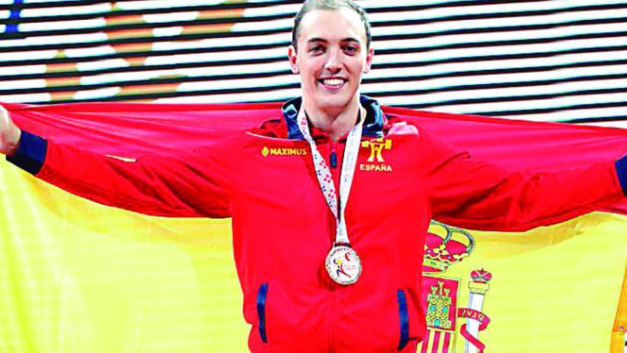 Andrés Mata, olímpico tinerfeño, posa orgulloso con la bandera de España y una de sus medallas al cuello.