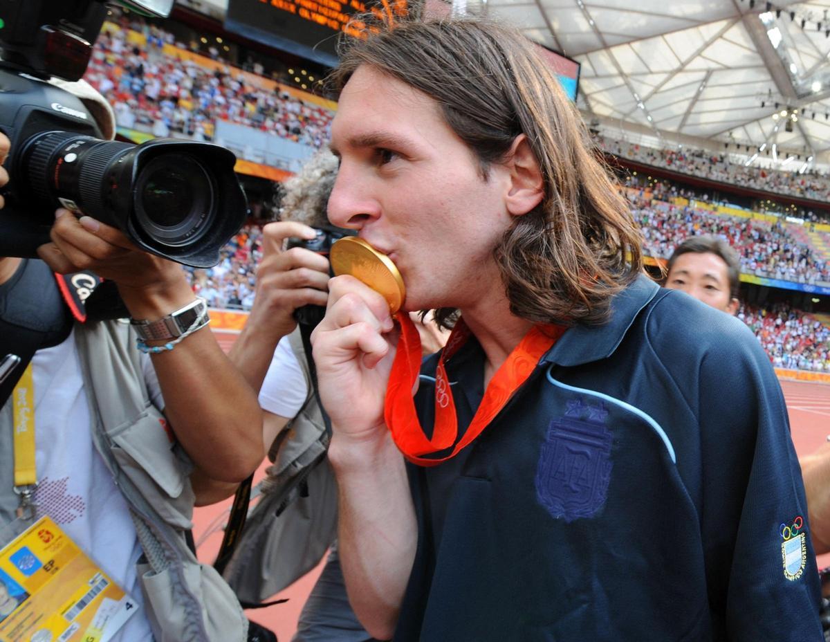 Lionel Messi besa su medalla de oro mientras abandona el terreno de juego tras asistir a la ceremonia de entrega de medallas del torneo olímpico de fútbol masculino, en el Estadio Nacional de Pekín, durante los Juegos Olímpicos de Pekín 2008. Lionel Messi besa su medalla de oro mientras abandona el terreno de juego tras asistir a la ceremonia de entrega de medallas del torneo olímpico de fútbol masculino, en el Estadio Nacional de Pekín, durante los Juegos Olímpicos de Pekín 2008.