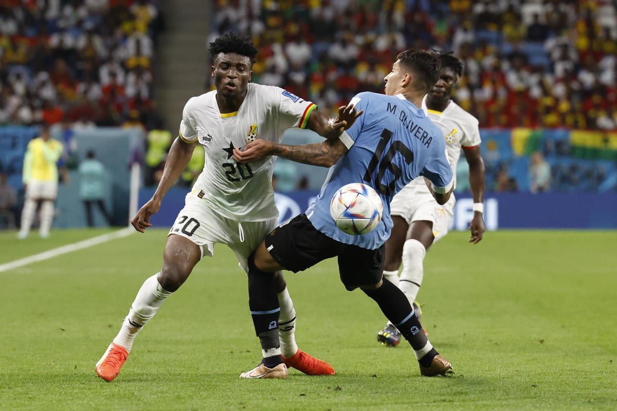 GR5236. AL-WAKRAH (CATAR), 02/12/2022.- Mohammed Kudus (i) de Ghana disputa un balón con Mathías Olivera de Uruguay hoy, en un partido de la fase de grupos del Mundial de Fútbol Qatar 2022 entre Ghana y Uruguay en el estadio Al-Janoub, en Al-Wakrah (Catar). EFE/ Esteban Biba