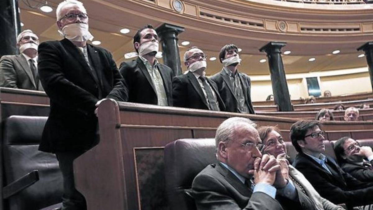 Diputados de Izquierda Plural, amordazados ayer durante el pleno del Congreso para protestar contra la ley de seguridad ciudadana.