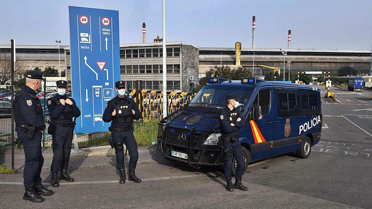 Agentes de la Policía Nacional a la entrada de Alu Ibérica A Coruña, en el registro de  marzo. |   // VÍCTOR ECHAVE