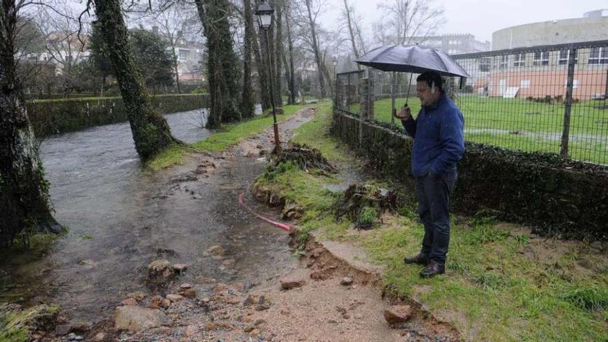 El alcalde de Cuntis, Manuel Campos, revisaba ayer los daños en el paseo fluvial del Gallo mientras se acercaba otro temporal. // Noé Parga