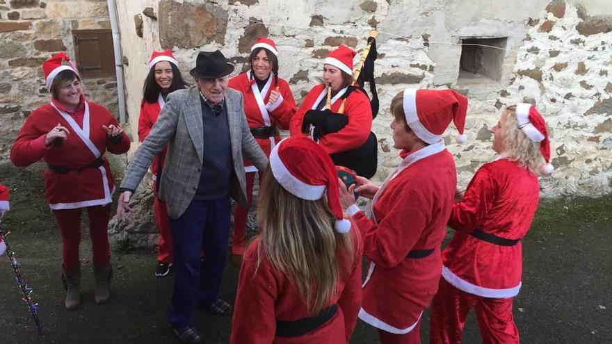 Andrés Pérez Laria saluda a las auxiliares de ayuda a domicilio caracterizadas como Papá Noel, ayer en su casa de El Picu.