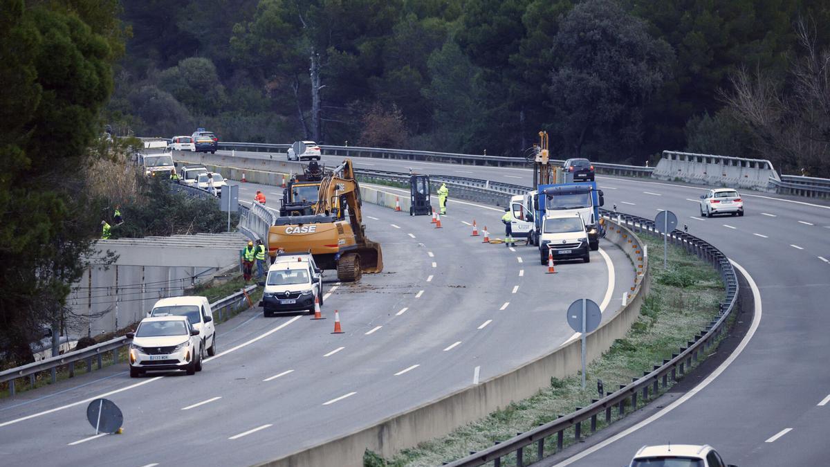 Una excavadora en el punto de la AP-7 en el que se desprendió el muro que causó el accidente ferroviario de Gelida el pasado martes.