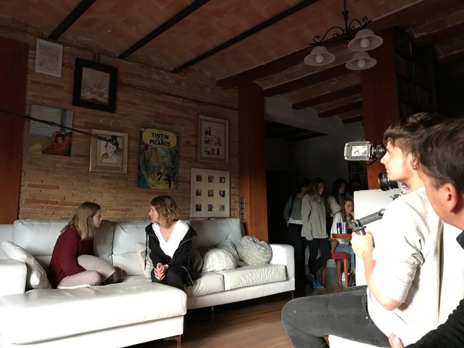 Laia Manzanares i Anna Alarcón interpreten una escena en una casa mentre un alumne la filma i d'altres (al fons) la segueixen en un monitor