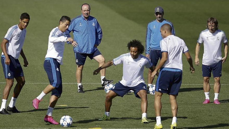 Cristiano Ronaldo toca el balón ante Marcelo, observado por Varane, Benítez, un ayudante de este, Pepe y Modric.