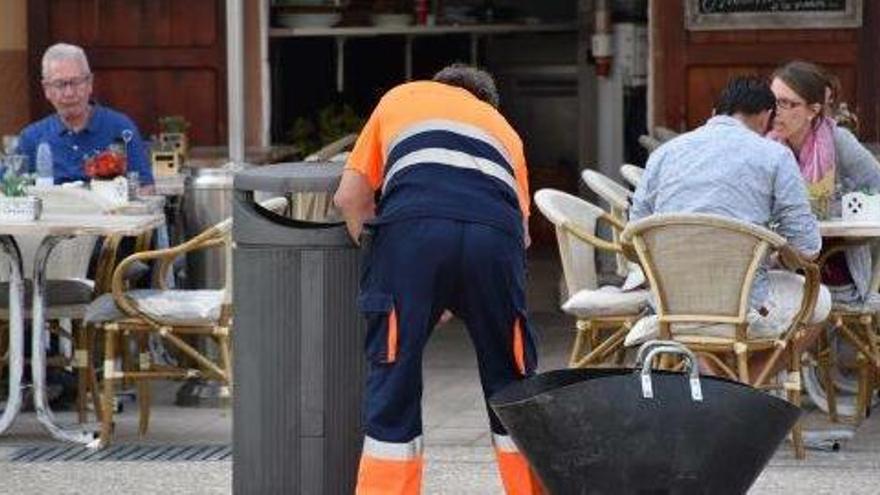 Un operario de la contrata de limpieza vacía una papelera en la plaza del Parque de Vila.