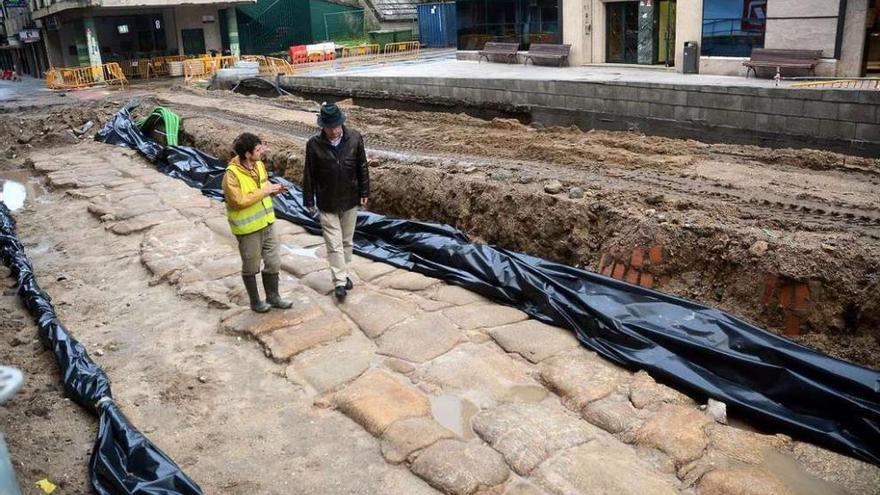 Louro y un arqueólogo sobre el amplio pavimento localizado en el subsuelo de la calle. // Rafa Vázquez