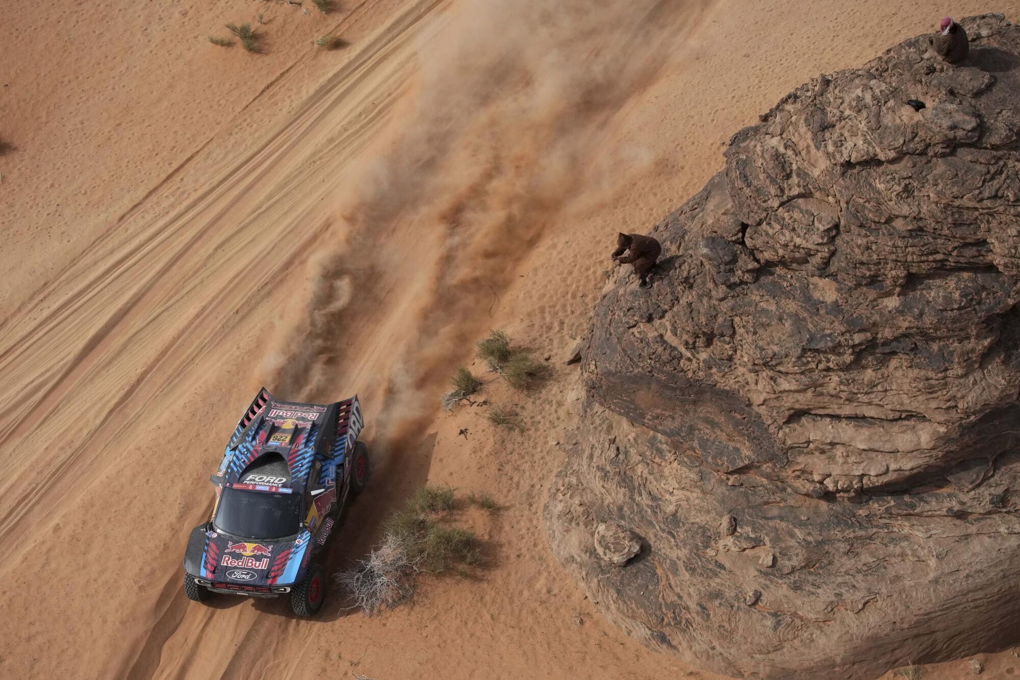A man takes a photo of Driver Mattias Ekstrom and co-driver Emil Bergkvist during the fifth stage of the Dakar Rally between Alula and Hail, Saudi Arabia, Thursday, Jan. 9, 2025. (AP Photo/Christophe Ena). EDITORIAL USE ONLY / ONLY ITALY AND SPAIN