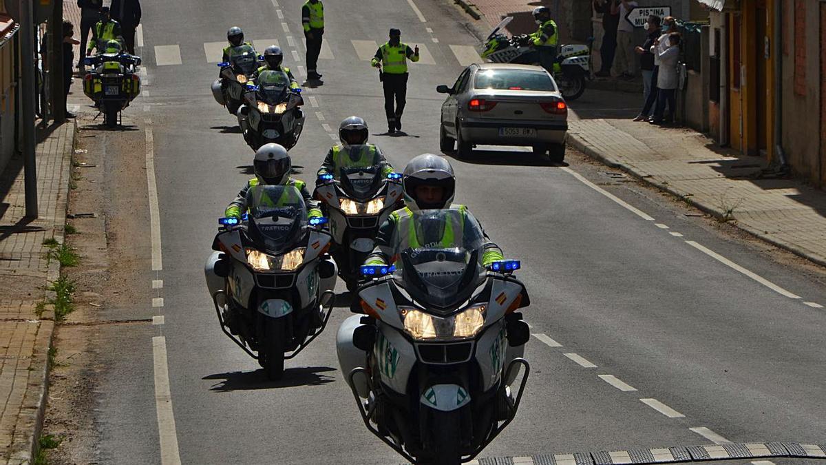 Las motocicletas de la Guardia Civil durante su recorrido por las carreteras de Aliste y a la izquierda los vehículos aparcados en Rabanales. | Ch. S.