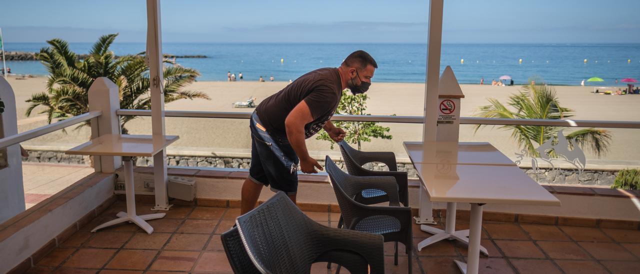 Un camarero prepara una terraza en una zona turística de Tenerife.