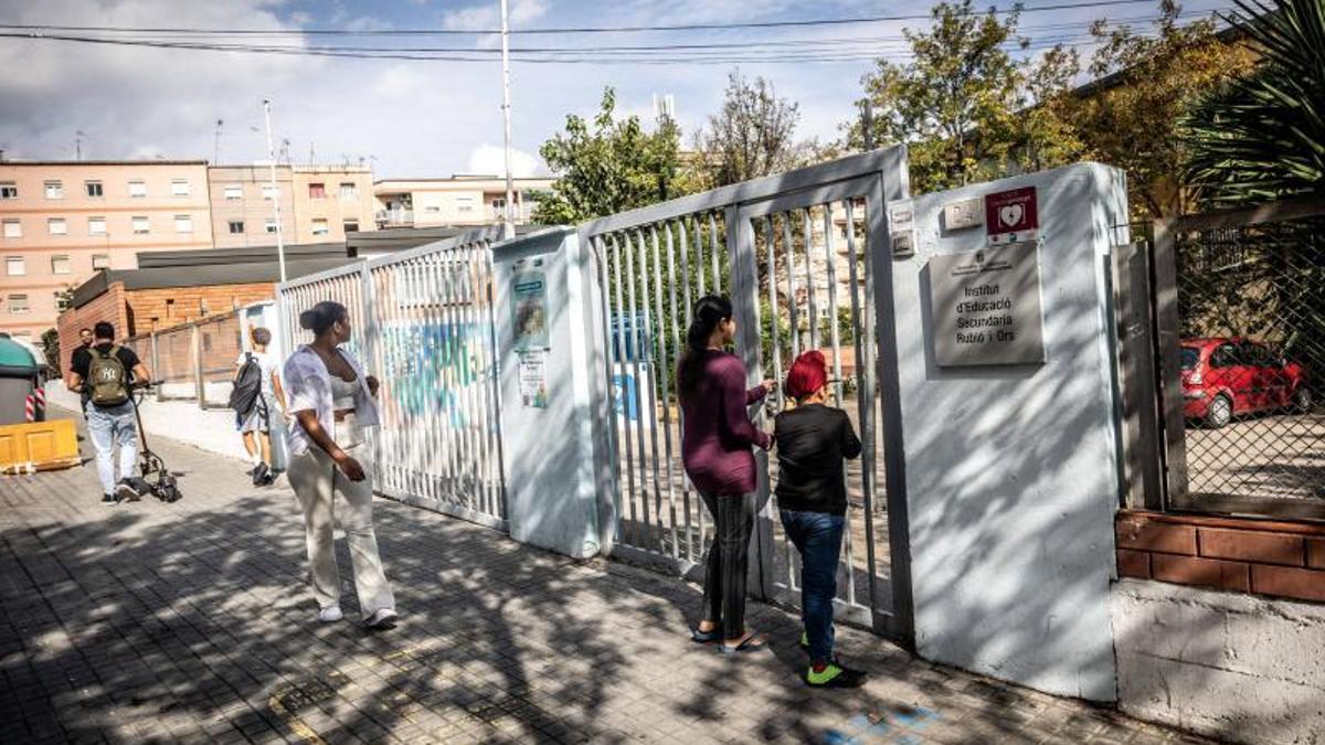 Familias esperan junto a la puerta del instituto Rubió i Ors de L'Hospitalet.