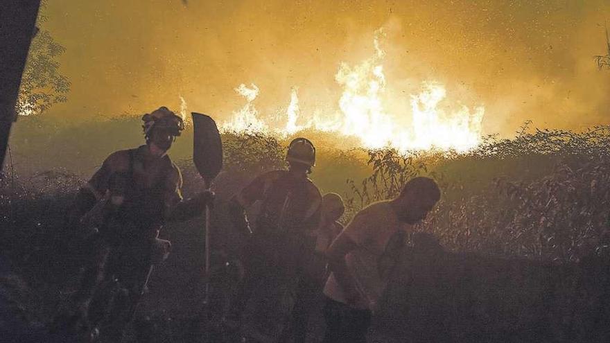Efectivos antiincendios y vecinos tratan de sofocar las llamas en Carballeda de Avia.