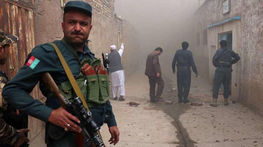 Oficial de policía afgano junto a una mezquita de Herat atacada ayer en un atentado suicida.