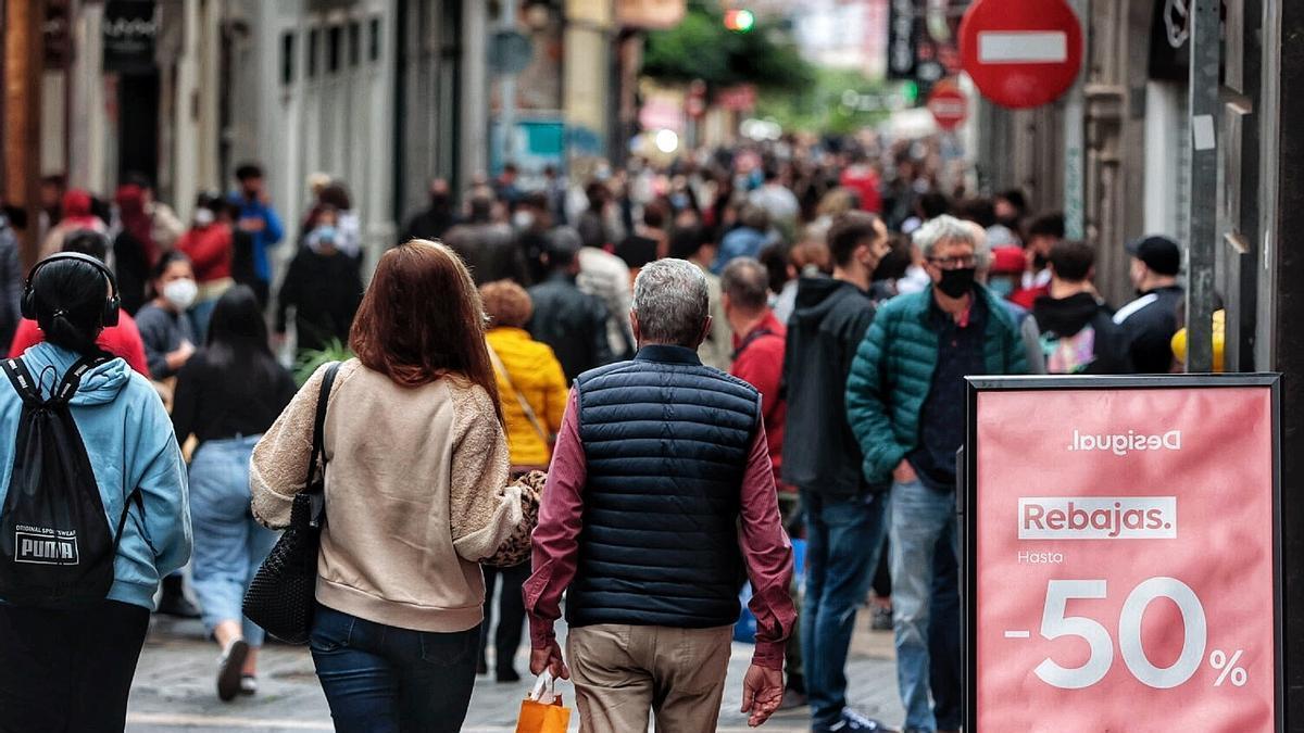 Varias personas pasean por una zona comercial de las Islas.