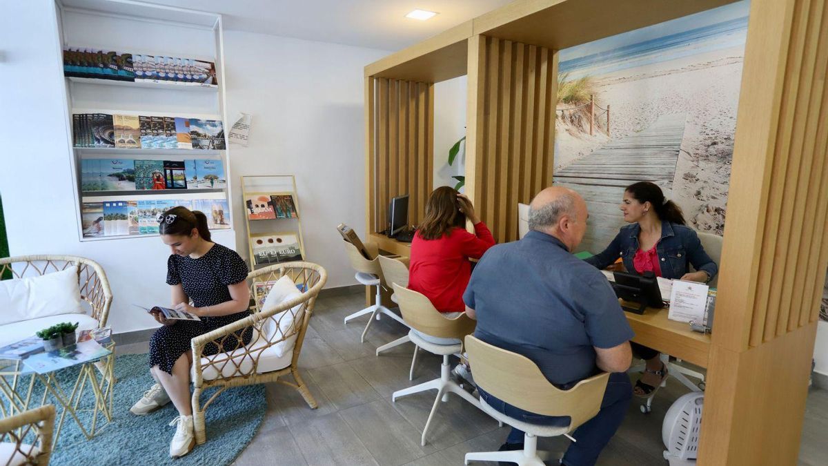 Clientes de una agencia de viajes organizando sus vacaciones para este verano.