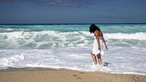 Una mujer pasea por la playa