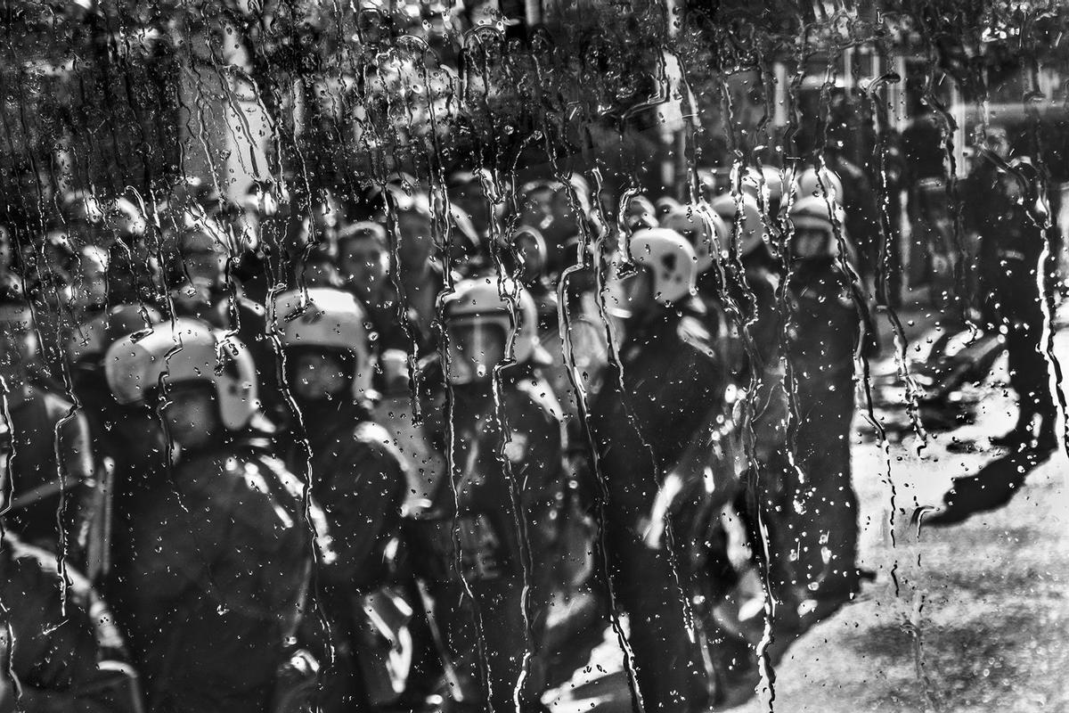 Foto de Ernesto Valverde, desde el bus del Olympiacos, de policias griegos, que protegían la llegada del equipo a un estadio en un día lluvioso.