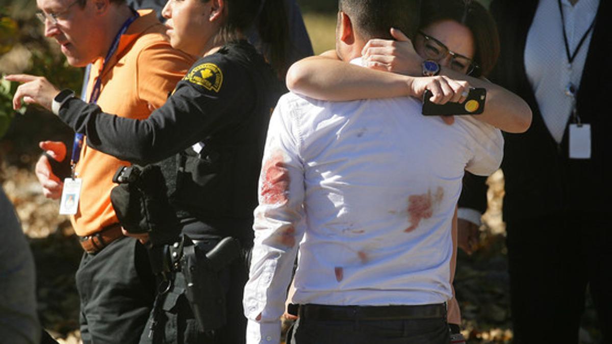 Una pareja se abraza tras el tiroteo en el centro de discapacitados de San Bernardino.