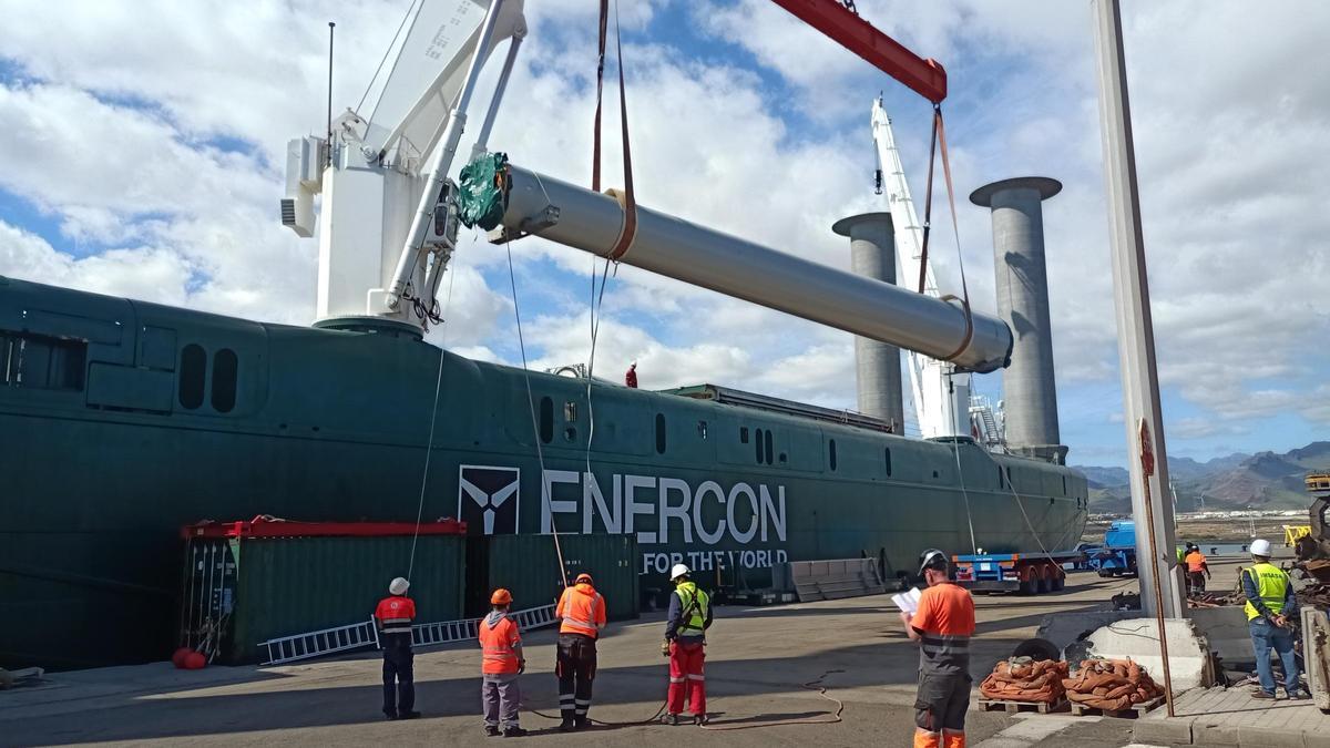Varios operarios desembarcan en el Puerto de Arinaga los componentes de un aerogenerador.