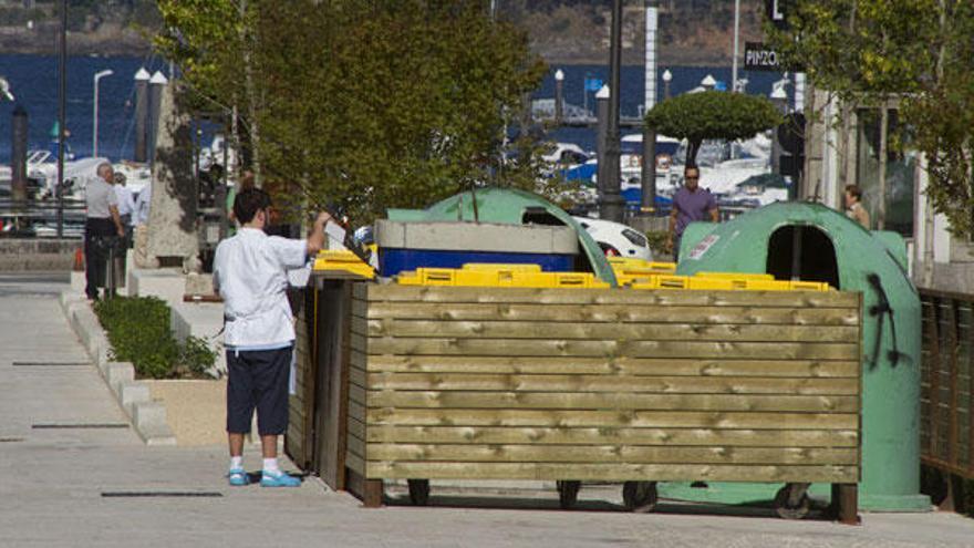 Un joven deposita unos residuos en uno de los contenedores de la calle Carabela Pinta.   // Adrián Irago