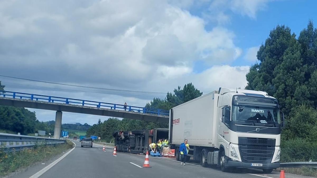 El camión volcado en la autovía del Cantábrico, a la altura del desvío a La Caridad.