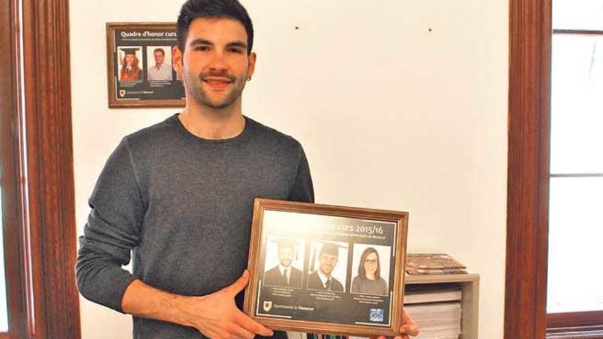 Pedro Quetglas posando con el cuadro de honor de los tres mejores estudiantes locales.