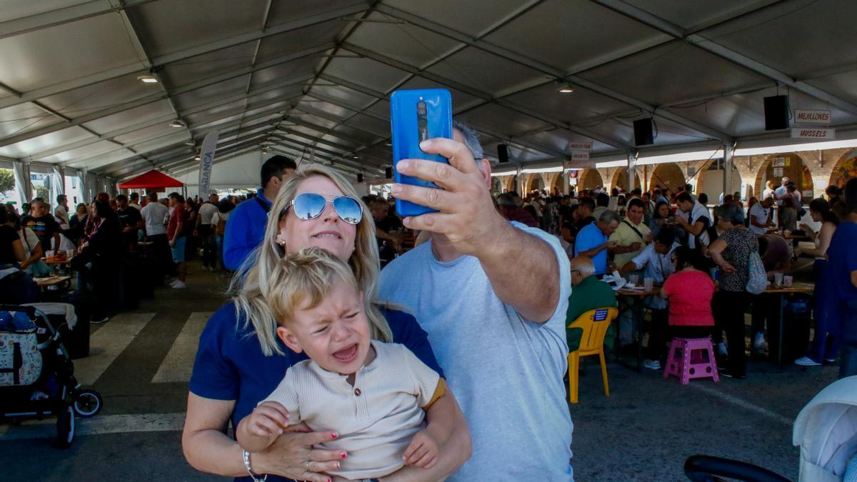 Una familia se hace un selfie ante la carpa de degustación de O Grove