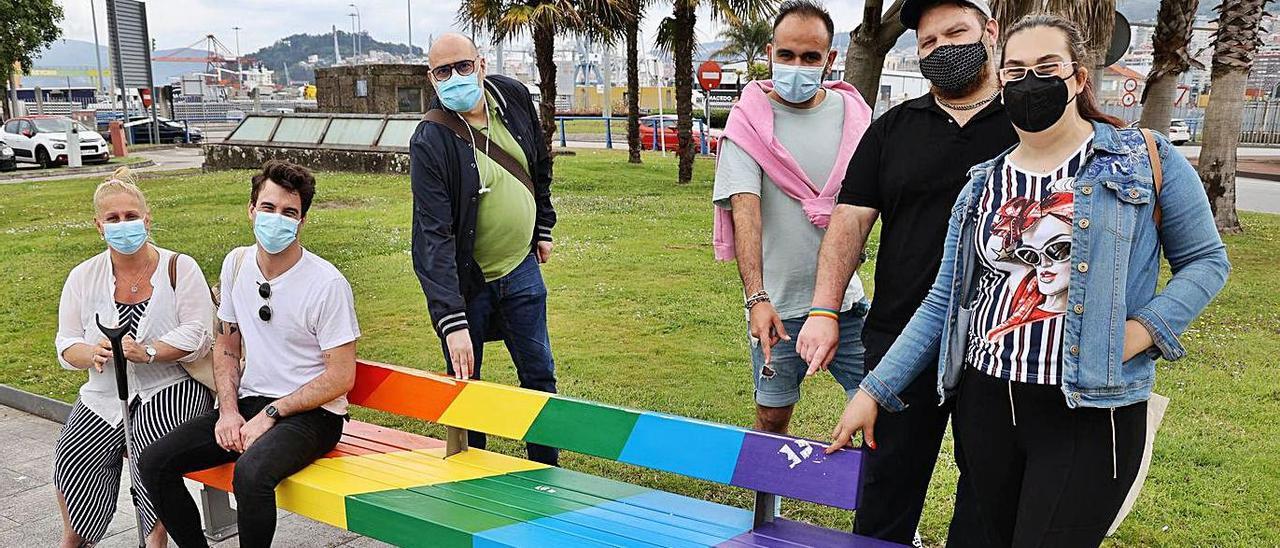 Miembros del colectivo LGTBI Pvlse, junto al banco que ha sido vandalizado.