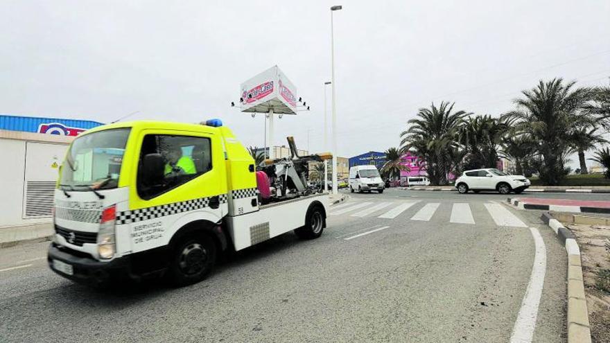 Uno de los vehículos que forman parte del servicio municipal de grúa circula, ayer, por las calles de Elche.