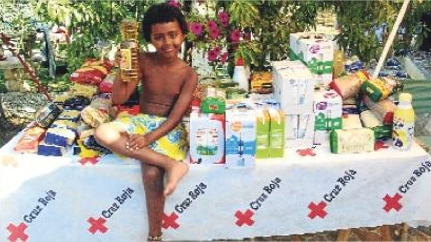 El pequeño Iago con los alimentos recogidos en el cumpleaños solidario.