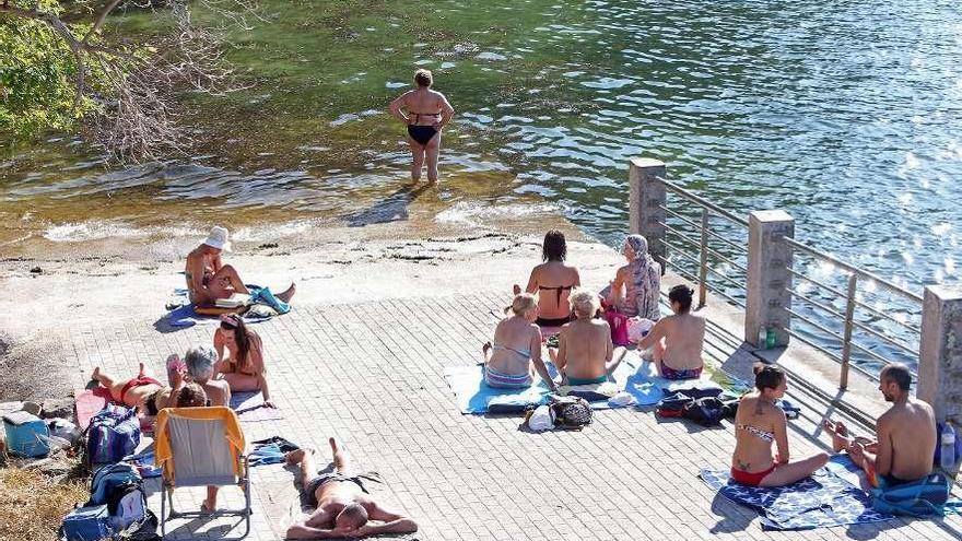 Bañistas disfrutan del calor en la Praia da Punta en Teis. // Marta G. Brea