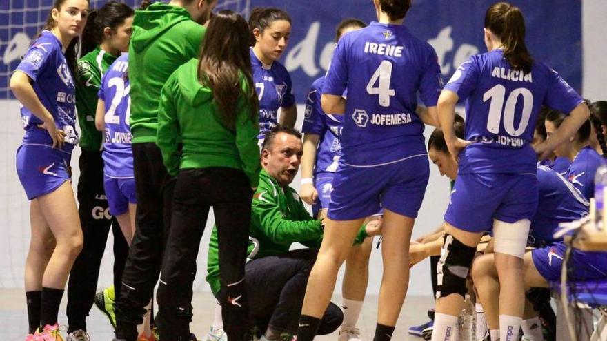 Alfredo Rodríguez, en cuclillas, da instrucciones a sus jugadoras durante un tiempo muerto.