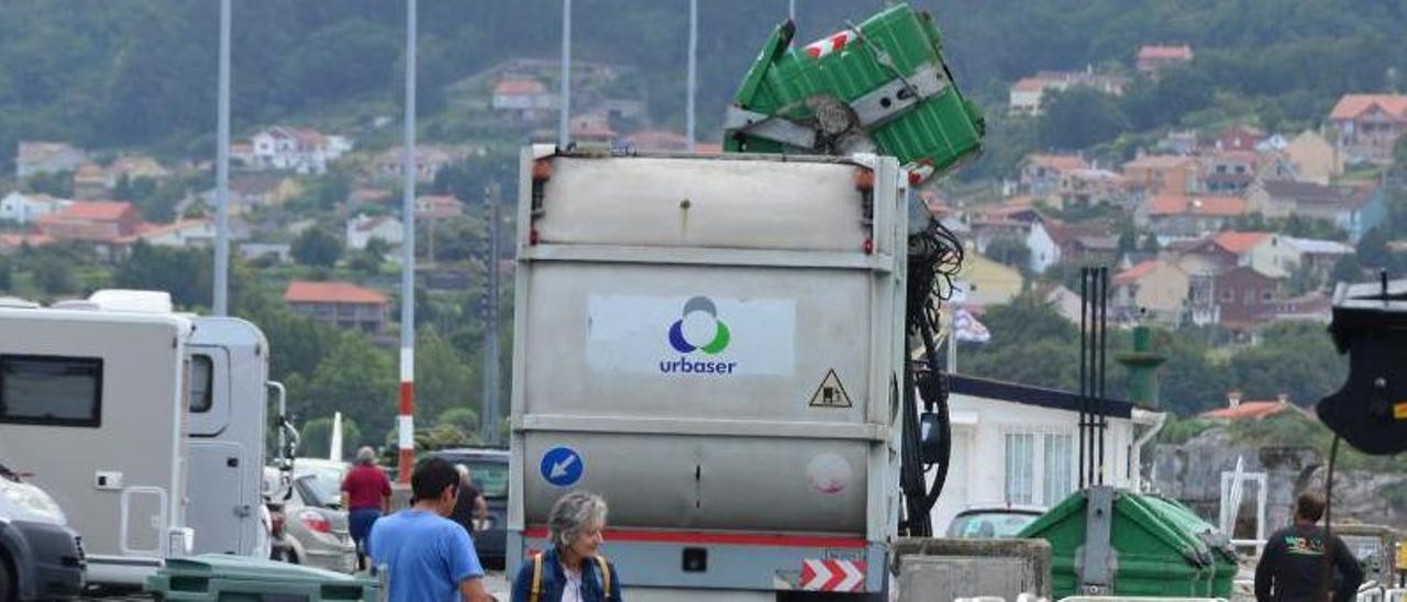 Un camión de la recogida de basuras de la comarca, este verano, trabajando en el centro de Bueu. |  GONZALO NÚÑEZ