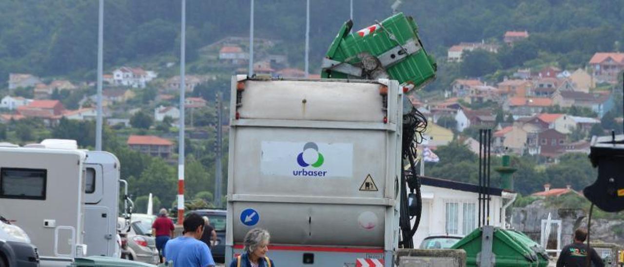 Un camión de la recogida de basuras de la comarca, este verano, trabajando en el centro de Bueu. |   // GONZALO NÚÑEZ