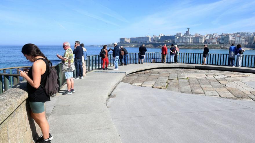 Viandantes disfrutan de de la jornada de sol, ayer, en el paseo marítimo de A Coruña. |   // CARLOS PARDELLAS