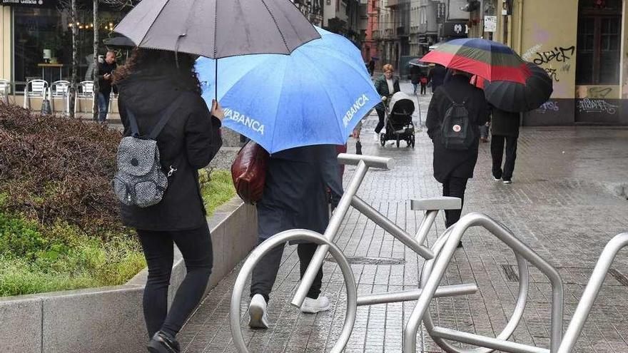 Viandantes con paraguas, ayer en el centro de A Coruña.