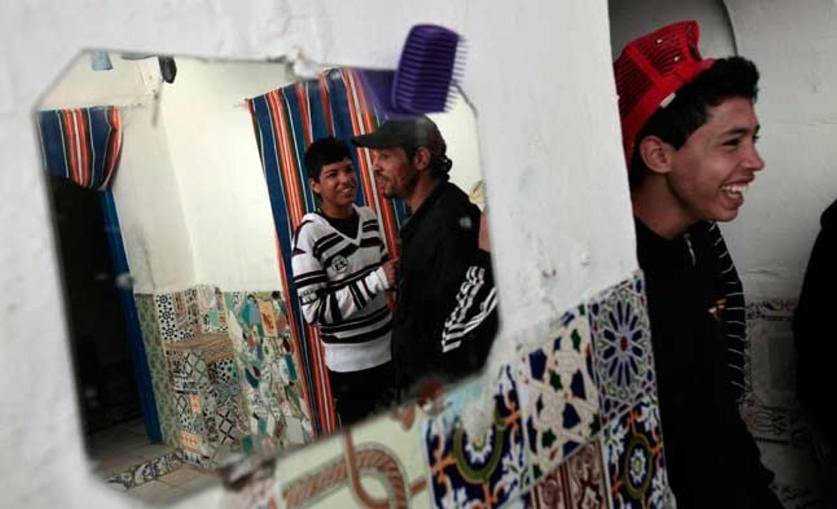 Uns joves tunisians es preparen per sortir a les seves cases del barri de barraques de Jabal al-Ahmar, a la capital del país.