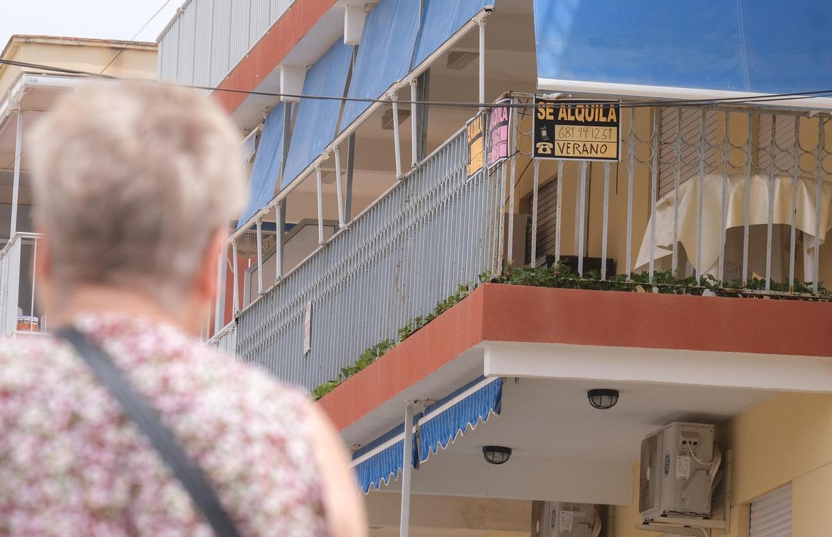 Una mujer mira los carteles de un apartamento turístico.