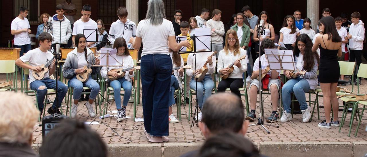 La profesora de música Esperanza Suárez, de espaldas, durante la pieza interpretada por los alumnos con ukelele en el patio del IES La Vaguada. | A. B.